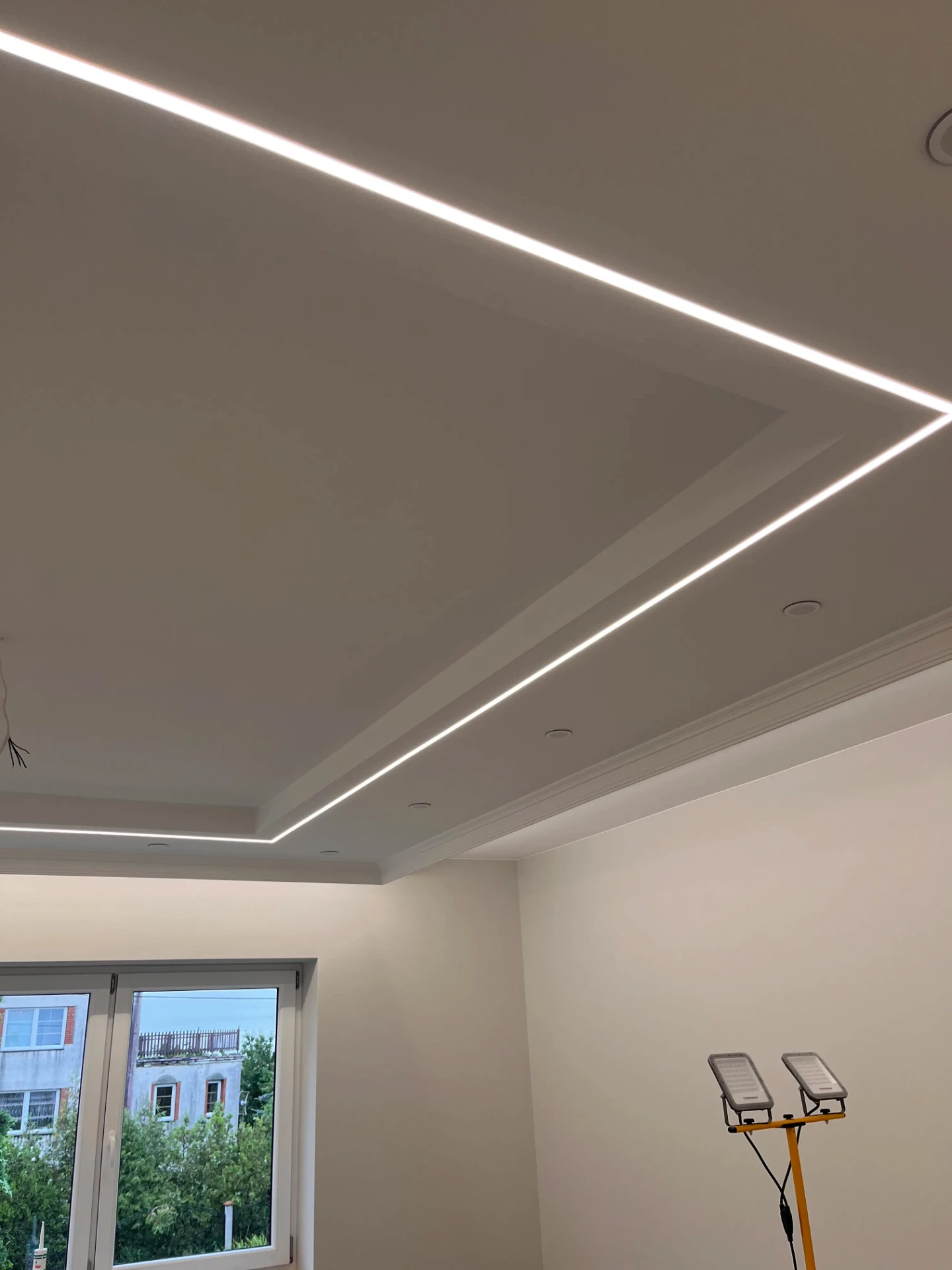 Sufit podwieszany z listwami LED w salonie